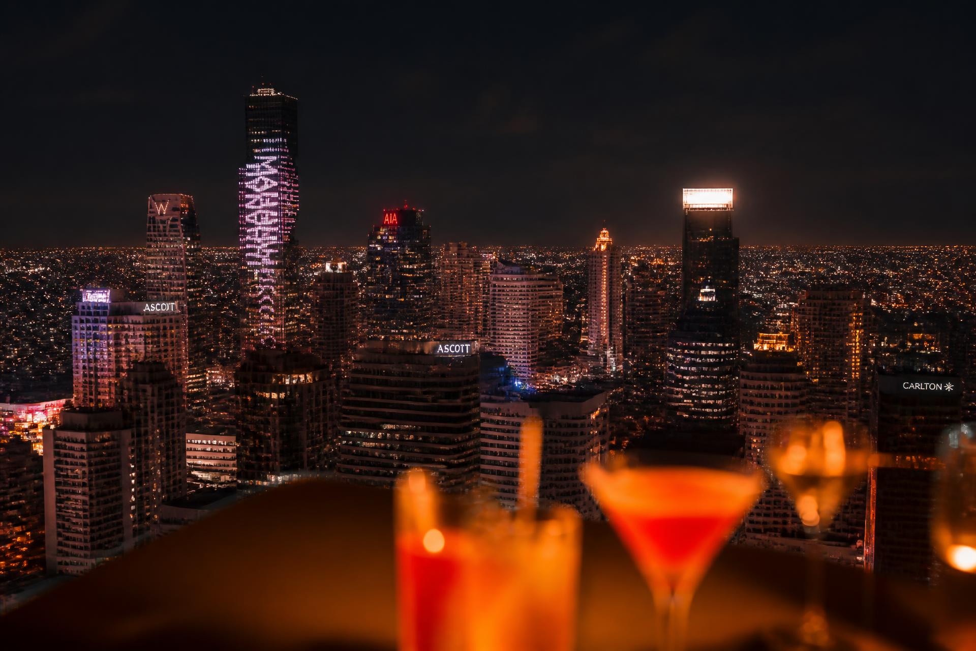 Bangkok skyline glowing at night seen from a rooftop bar